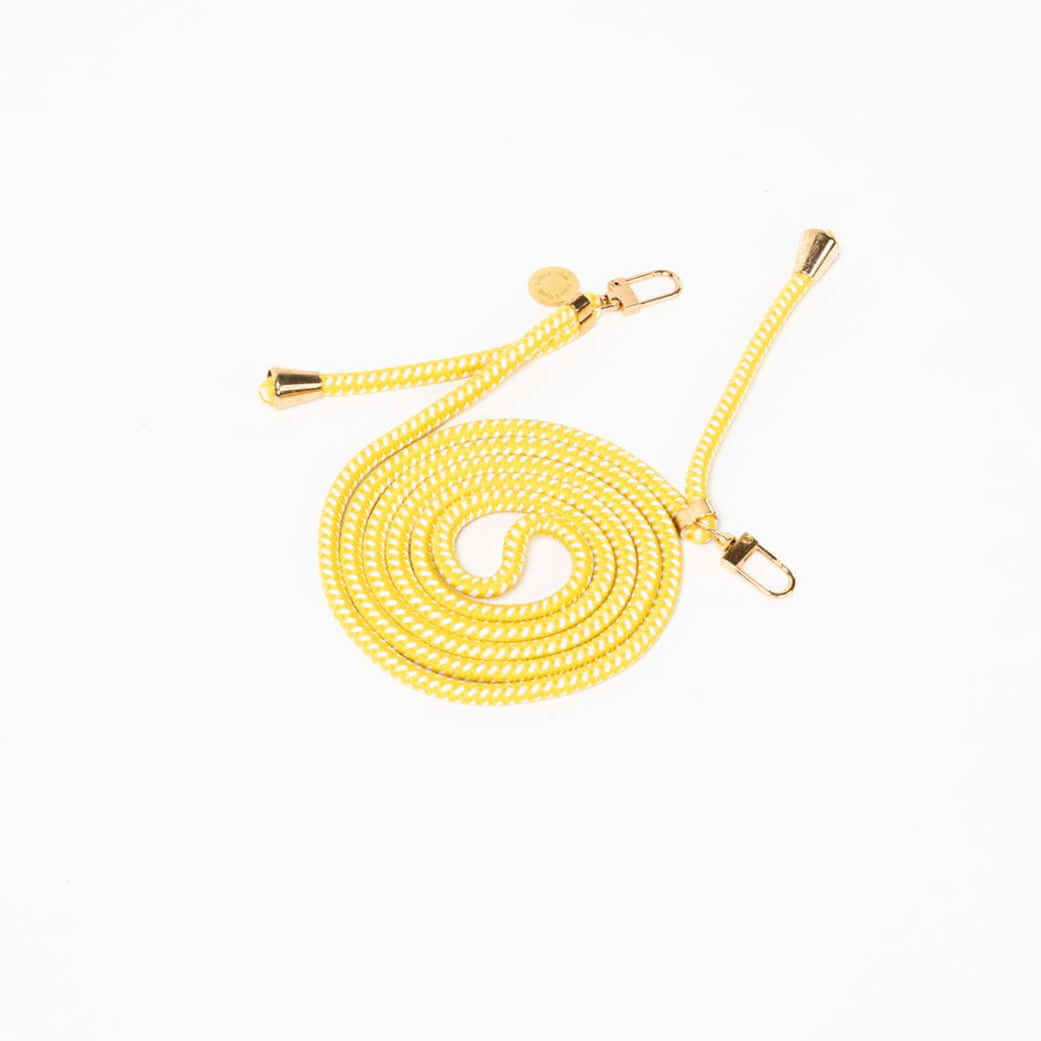 Yellow and white braided Multi Colorful PHONE CORD coiled with gold-tone hardware on a white background.