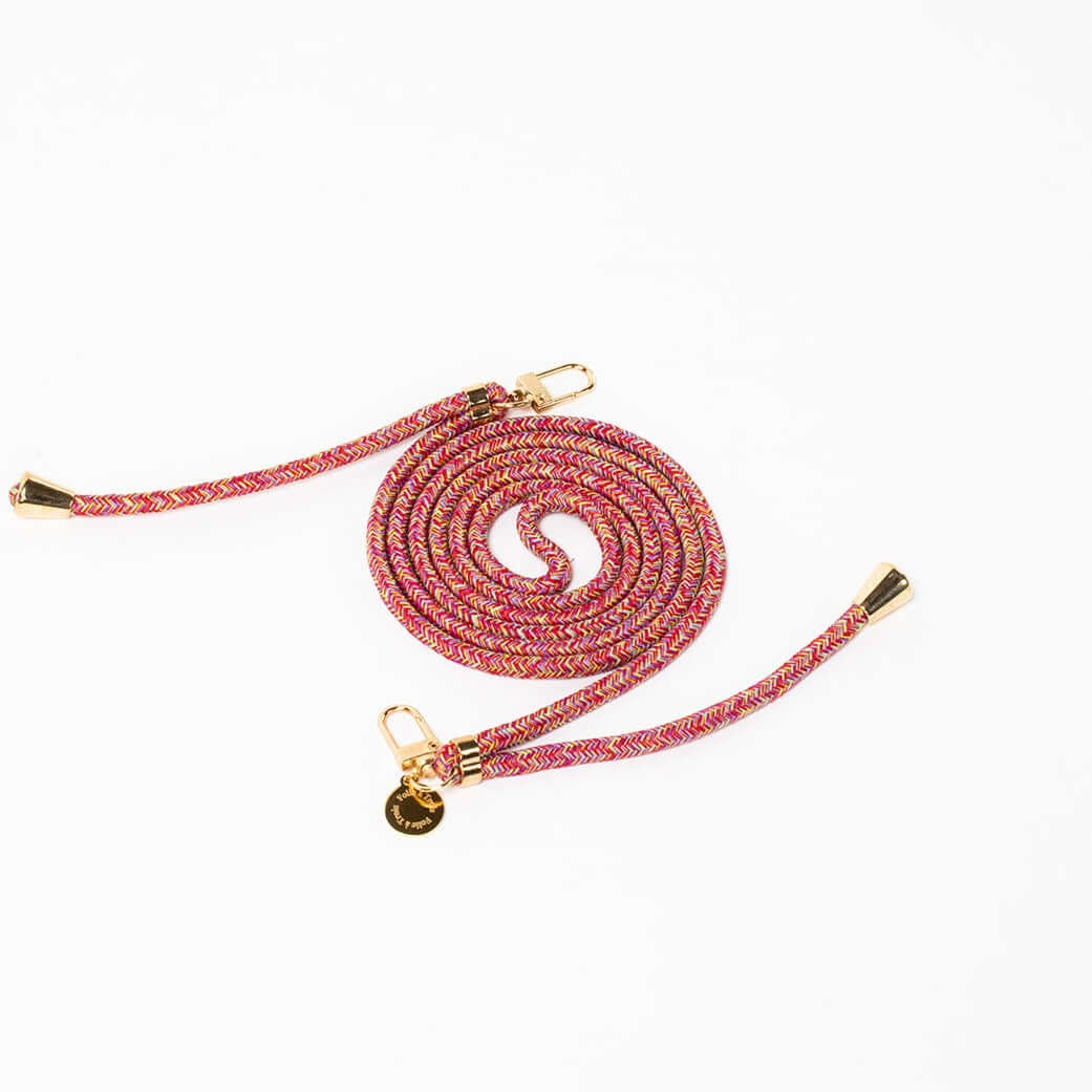 Pink, orange and purple multicolor patterned Multi Colorful PHONE CORD coiled with gold-tone hardware on white.
