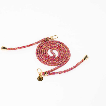 Pink, orange and purple multicolor patterned Multi Colorful PHONE CORD coiled with gold-tone hardware on white.