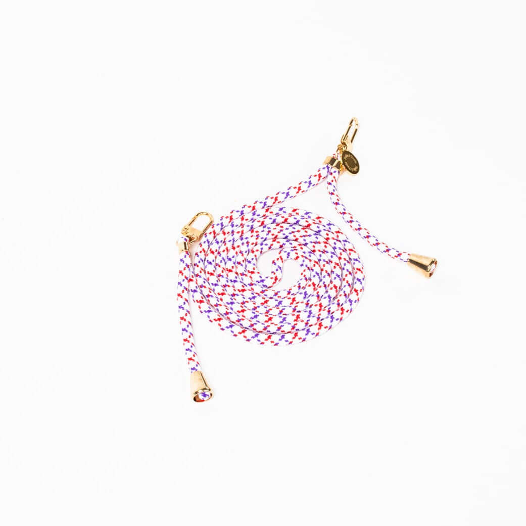 Red, purple and white patterned Multi Colorful PHONE CORD coiled with gold-tone hardware on white.