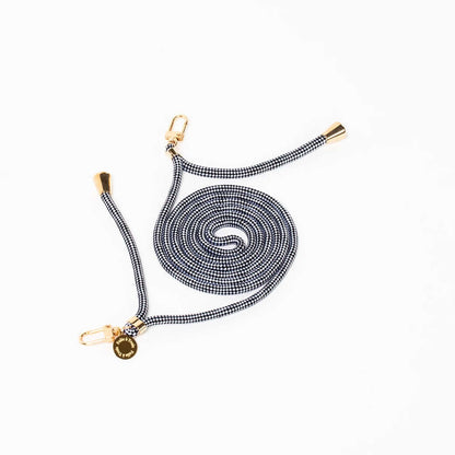 Black and white houndstooth Multi Colorful PHONE CORD coiled with gold-tone hardware on a white background.
