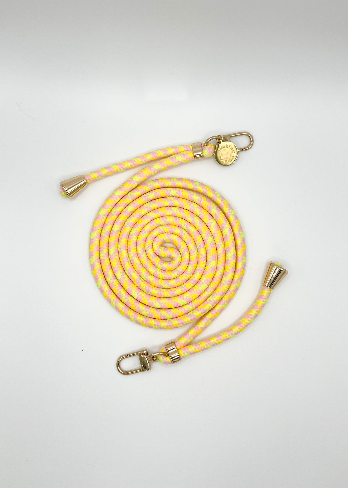 Pale yellow and pink patterned Multi Colorful PHONE CORD coiled with gold-tone hardware on a white background.
