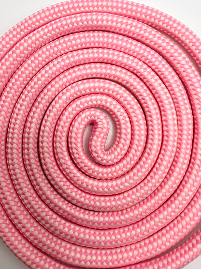 Overhead close-up of a pink and white Multi Colorful PHONE CORD coiled tightly into a spiral.