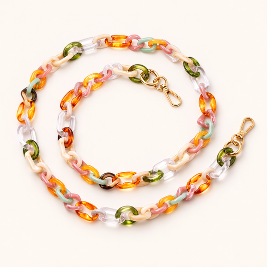 A coiled acrylic link phone chain in green, orange, pink, and cream tones with a gold clasp, shown on a cream background.