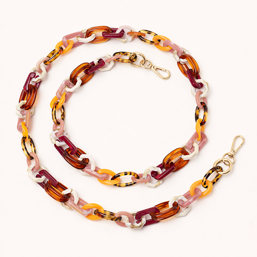 A coiled acrylic link phone chain in burgundy, tortoiseshell, orange, and white tones with a gold clasp, shown on a cream background.