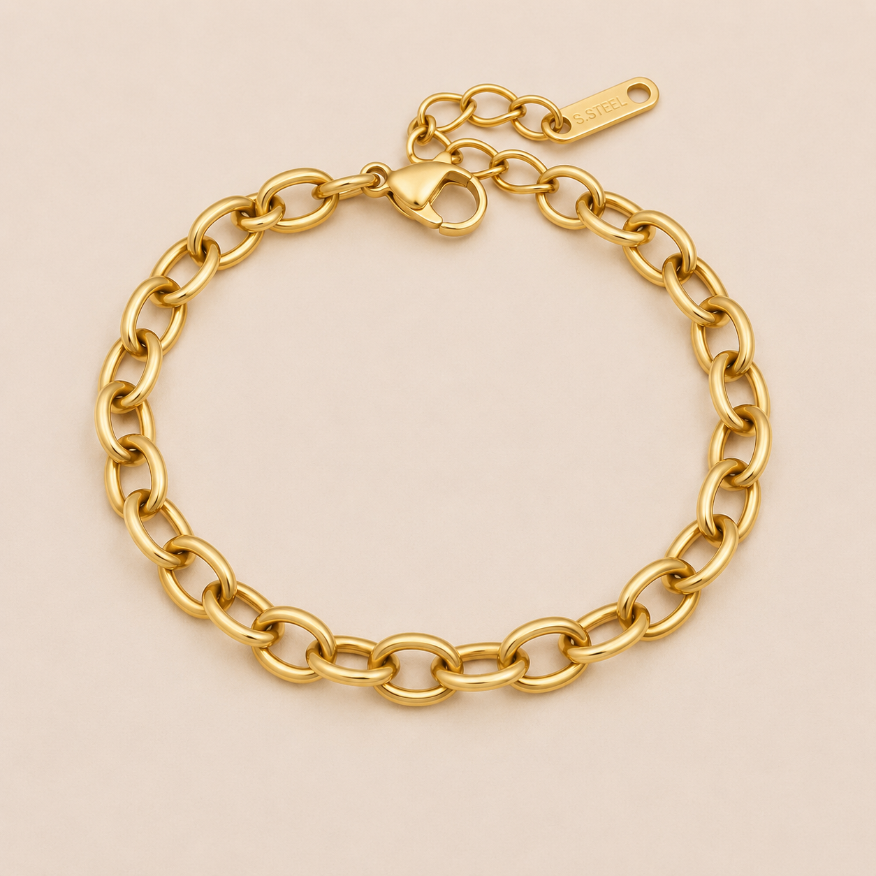 Nadia BRACELET in gold with a classic oval cable-link chain and a lobster clasp, shown flat on a soft beige background.
