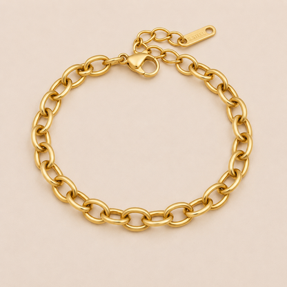 Nadia BRACELET in gold with a classic oval cable-link chain and a lobster clasp, shown flat on a soft beige background.