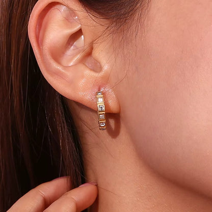No Filter Earring worn on the ear in gold, the square crystal hoop framing the lobe up close nicely.