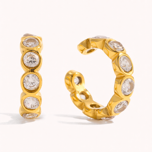 Gold Nomad ear cuff fully set with round bezel crystals in an open C-shape, shown from a front and side angle.