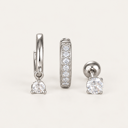 The Folie à Trois Noor SET in silver: a hoop with a dangling round crystal, a pavé bar hoop and a round bezel stud.