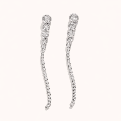Odette Earrings trail a graduated line of round crystals from a bezel-set top stud into a delicate pave curve, in silver tone.