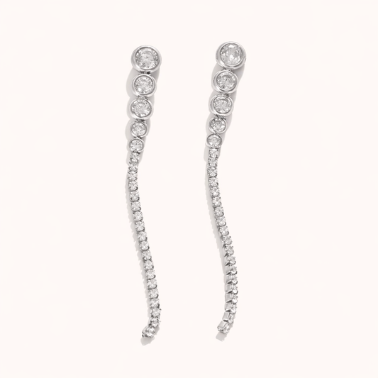 Odette Earrings trail a graduated line of round crystals from a bezel-set top stud into a delicate pave curve, in silver tone.