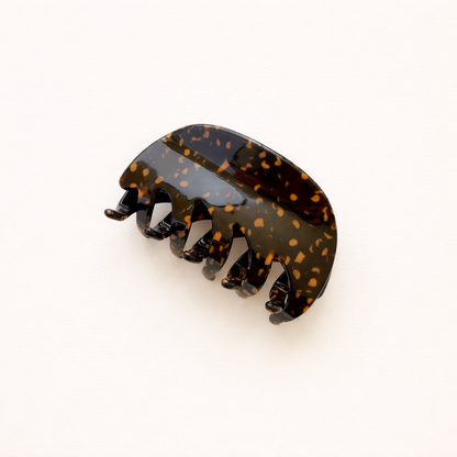 A single dark brown and gold speckled acetate hair claw clip shown on a plain background.