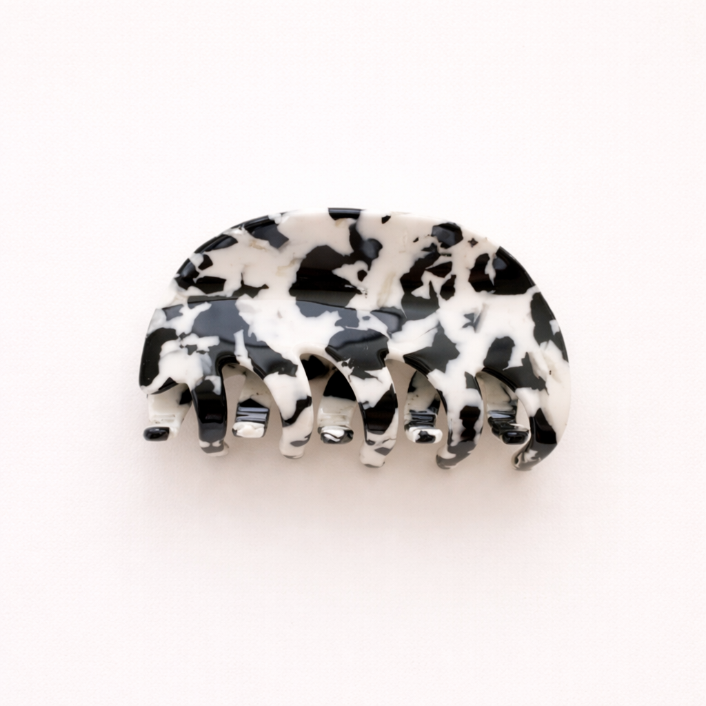 A single black and white mottled acetate hair claw clip shown on a plain background.