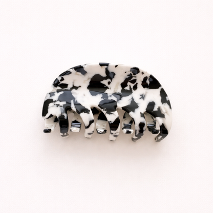 A single black and white mottled acetate hair claw clip shown on a plain background.