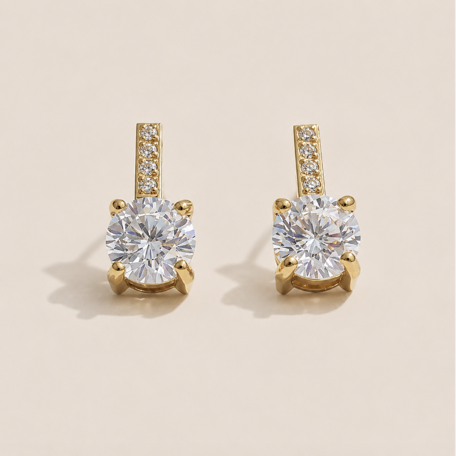 Gold stud earrings with a round white zirconia solitaire below a pavé bar on a cream backdrop — Folie à Trois Orbit EARRINGS