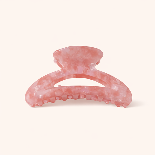 Pink marbled acetate arched claw clip from the Palm Springs HAIR CLIP collection, on a cream studio background.