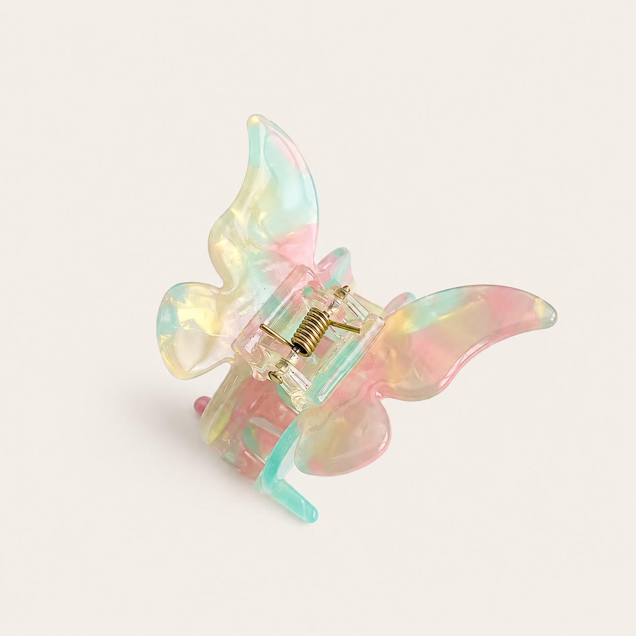 Papillon HAIR CLIP butterfly claw clip in pastel pink, yellow and blue iridescent resin with a gold spring, on off-white.