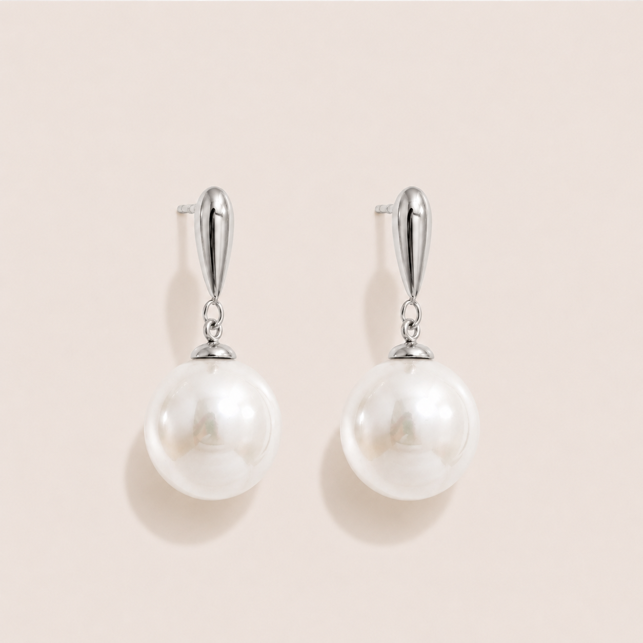 Silver drop earrings with a teardrop post and a large round white pearl on a cream backdrop — Folie à Trois Perle Drop EARRINGS