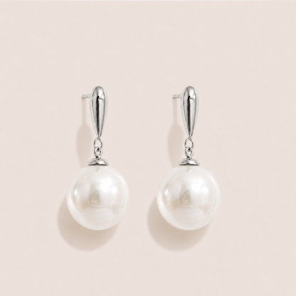 Silver drop earrings with a teardrop post and a large round white pearl on a cream backdrop — Folie à Trois Perle Drop EARRINGS