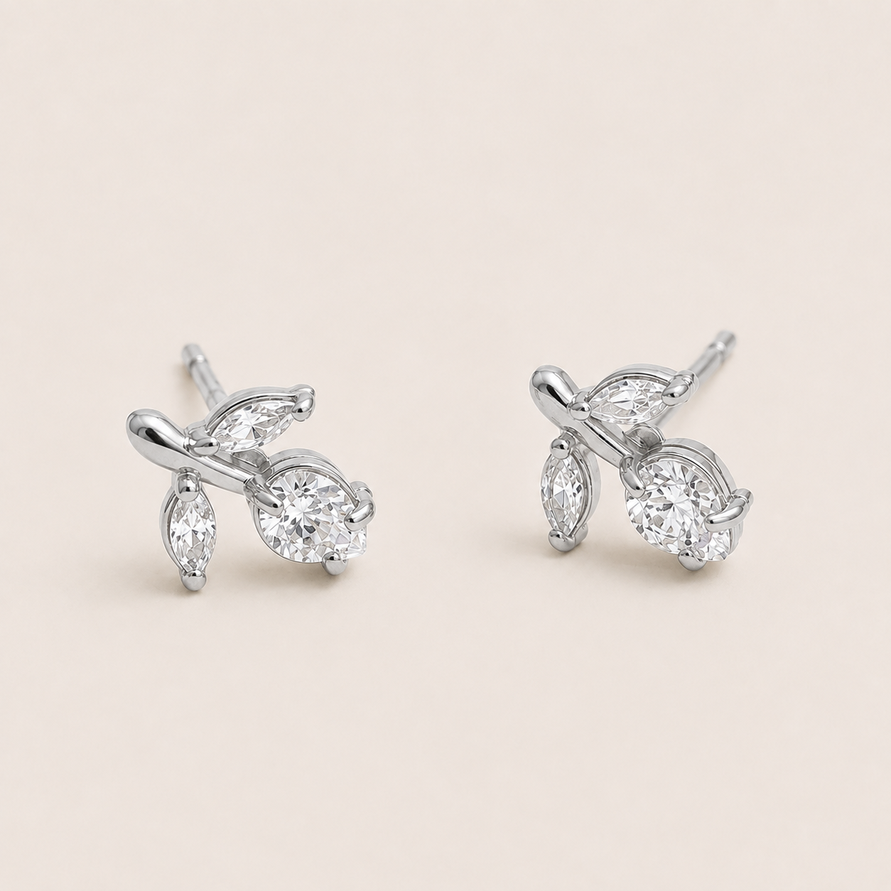 Silver vine-shaped stud earrings clustering marquise and round white zirconia stones on a cream backdrop — Folie à Trois Petiole EARRINGS