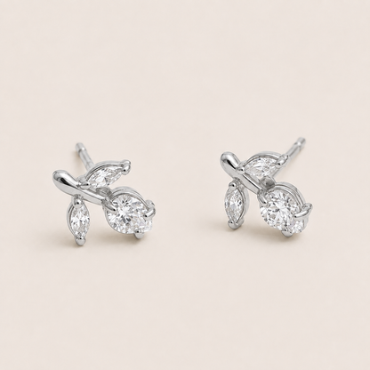 Silver vine-shaped stud earrings clustering marquise and round white zirconia stones on a cream backdrop — Folie à Trois Petiole EARRINGS