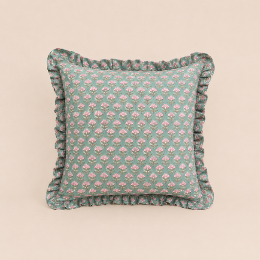 Sage green square cushion with a repeating pink floral bud print and ruffled trim, the Pipli Green Square Cushion on a neutral background.