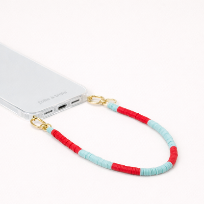 Red and turquoise heishi bead Poppy SHORT PHONE CORD clipped to a clear phone case with gold hardware.