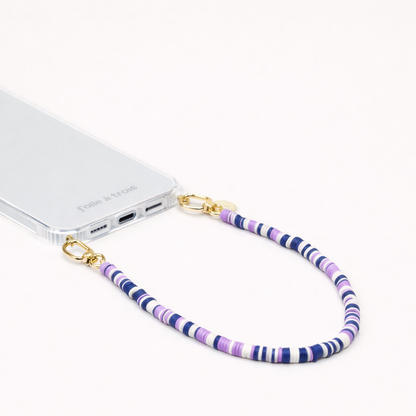 Navy, lavender, and white heishi bead Poppy SHORT PHONE CORD clipped to a clear phone case with gold hardware.