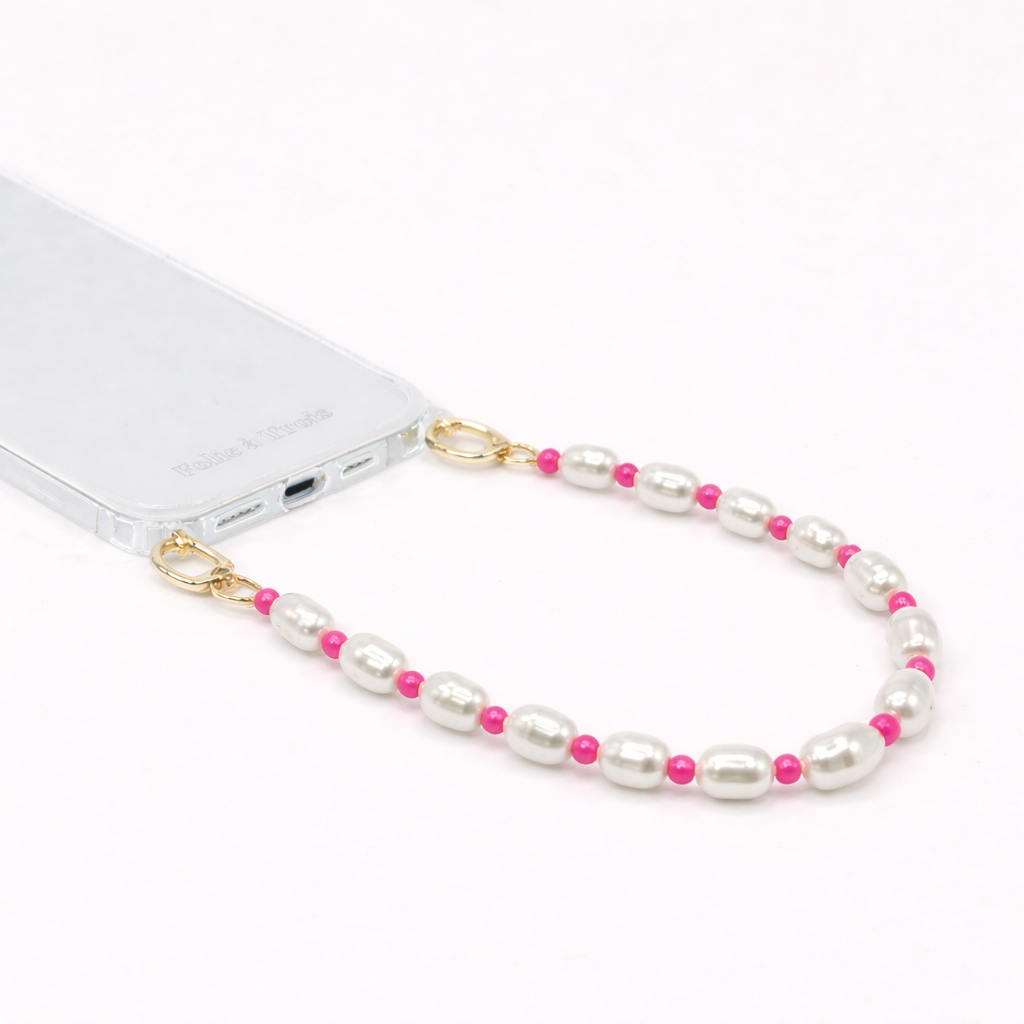 White pearl and pink bead Posy Pearl SHORT PHONE STRAP clipped to a clear phone case with gold hardware.