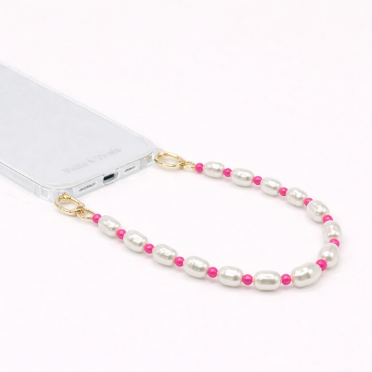 White pearl and pink bead Posy Pearl SHORT PHONE STRAP clipped to a clear phone case with gold hardware.