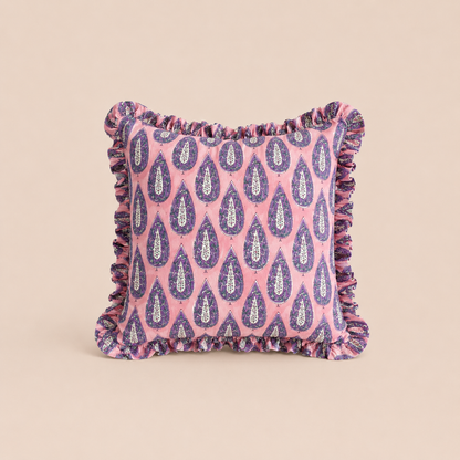 Purple Rain Square cushion in pink with a repeating purple and white paisley teardrop print and a delicate ruffled border.