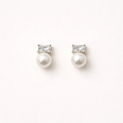 Radiant Reverie Earrings pair a clear baguette-cut stone with a round pearl below, set in polished silver.