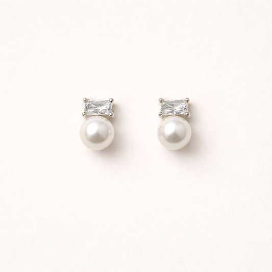 Radiant Reverie Earrings pair a clear baguette-cut stone with a round pearl below, set in polished silver.