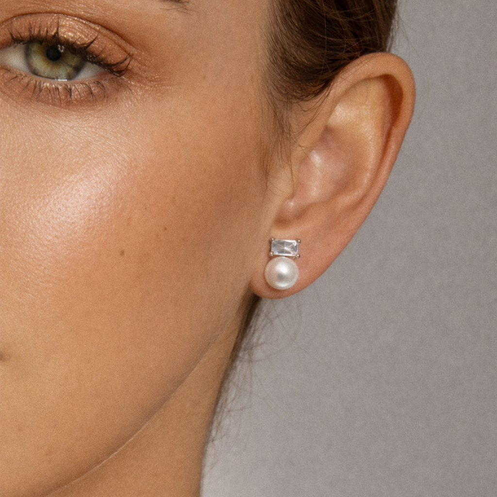 Worn as a stud, Radiant Reverie Earrings show their baguette stone and pearl resting neatly at the earlobe.