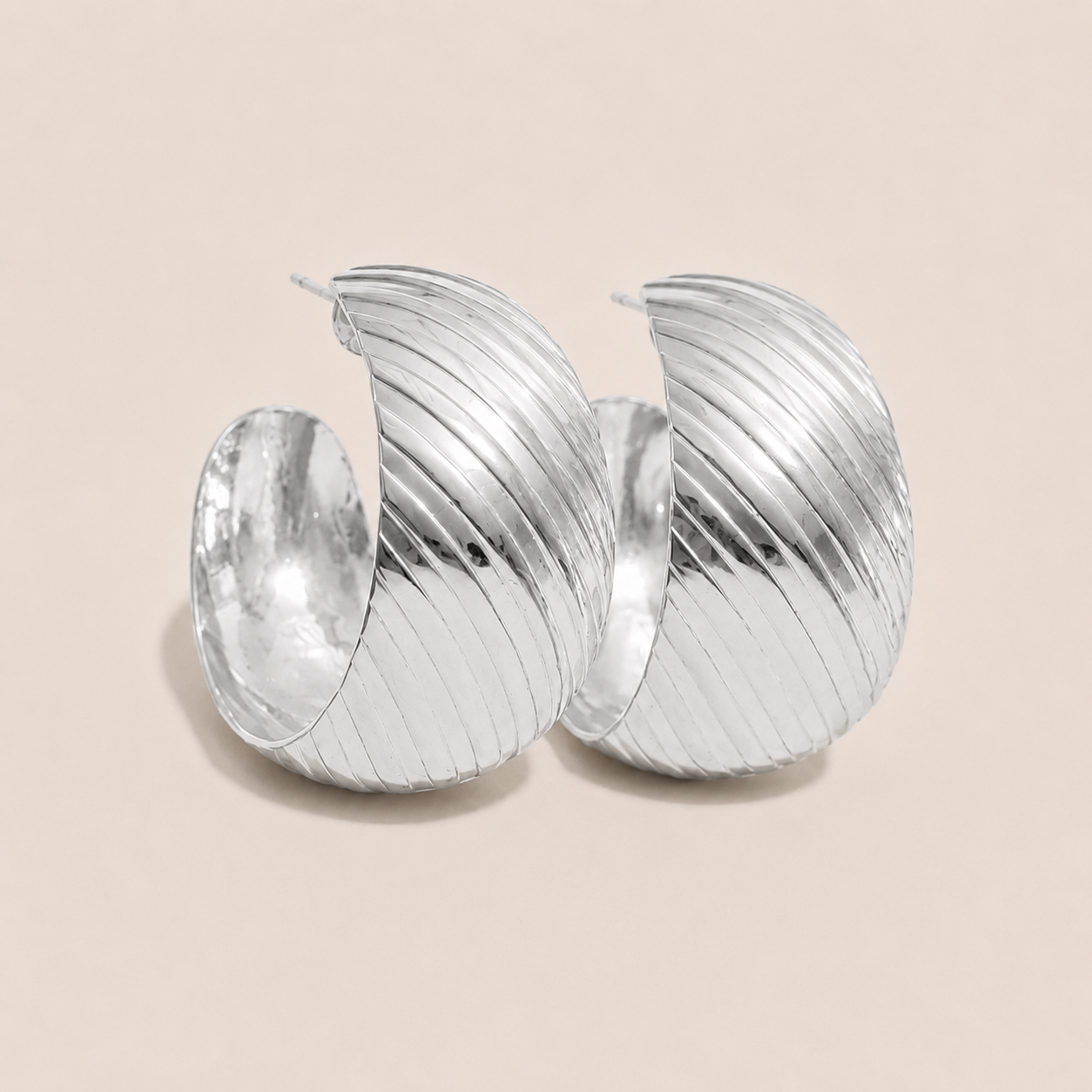 Chunky silver hoop earring with a ribbed, twisted texture and polished finish — Folie à Trois Rally EARRINGS.