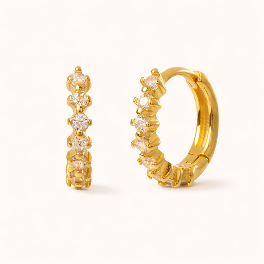 Retro Filter Earrings in gold with clear crystals, a huggie hoop set with five graduated round stones in a row.