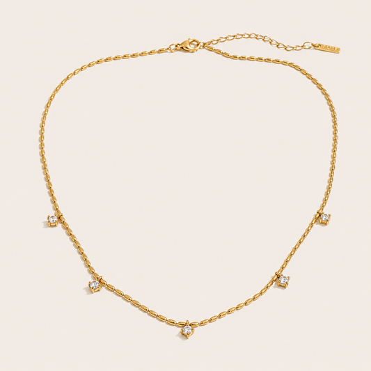 Gold station necklace with five round white zirconia charms spaced along a fine beaded chain — Folie à Trois Reverie NECKLACE.
