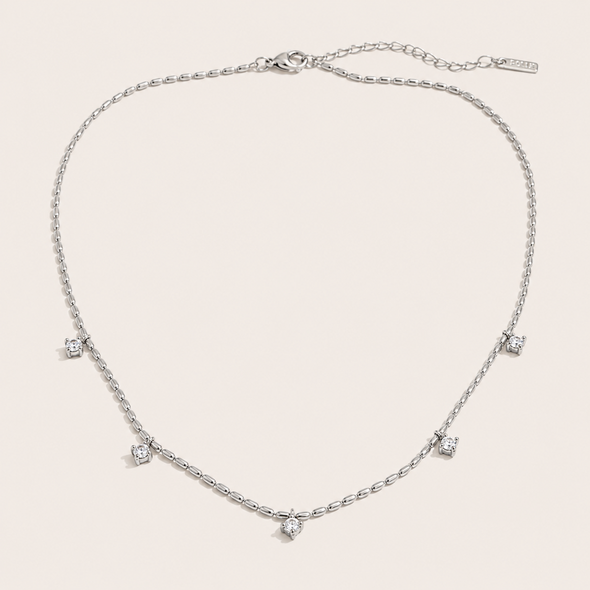 Silver station necklace with five round white zirconia charms spaced along a fine beaded chain — Folie à Trois Reverie NECKLACE.