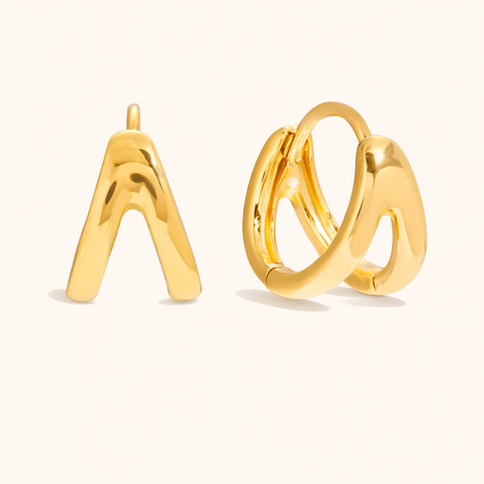 Roadtrip Earrings shown in gold, a sculptural triangular stud and a chunky double-band huggie hoop, viewed from front and side.