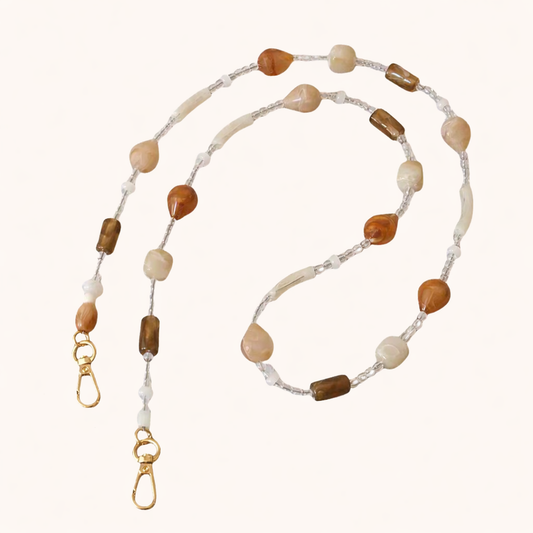 Mixed stone beaded Romee long phone chain in cream, tan, and brown tones, coiled flat with gold clasps.