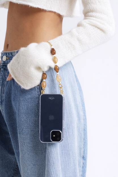 Model holds her phone by the mixed stone beaded Romee strap, phone in a navy case at the hip.