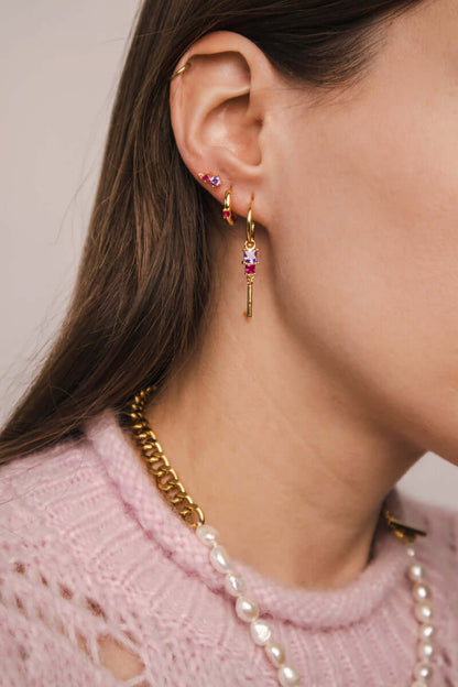 A model wears the Rosa SET in gold with lilac and pink stones, layering the bar-dangle hoop earring among other ear piercings.