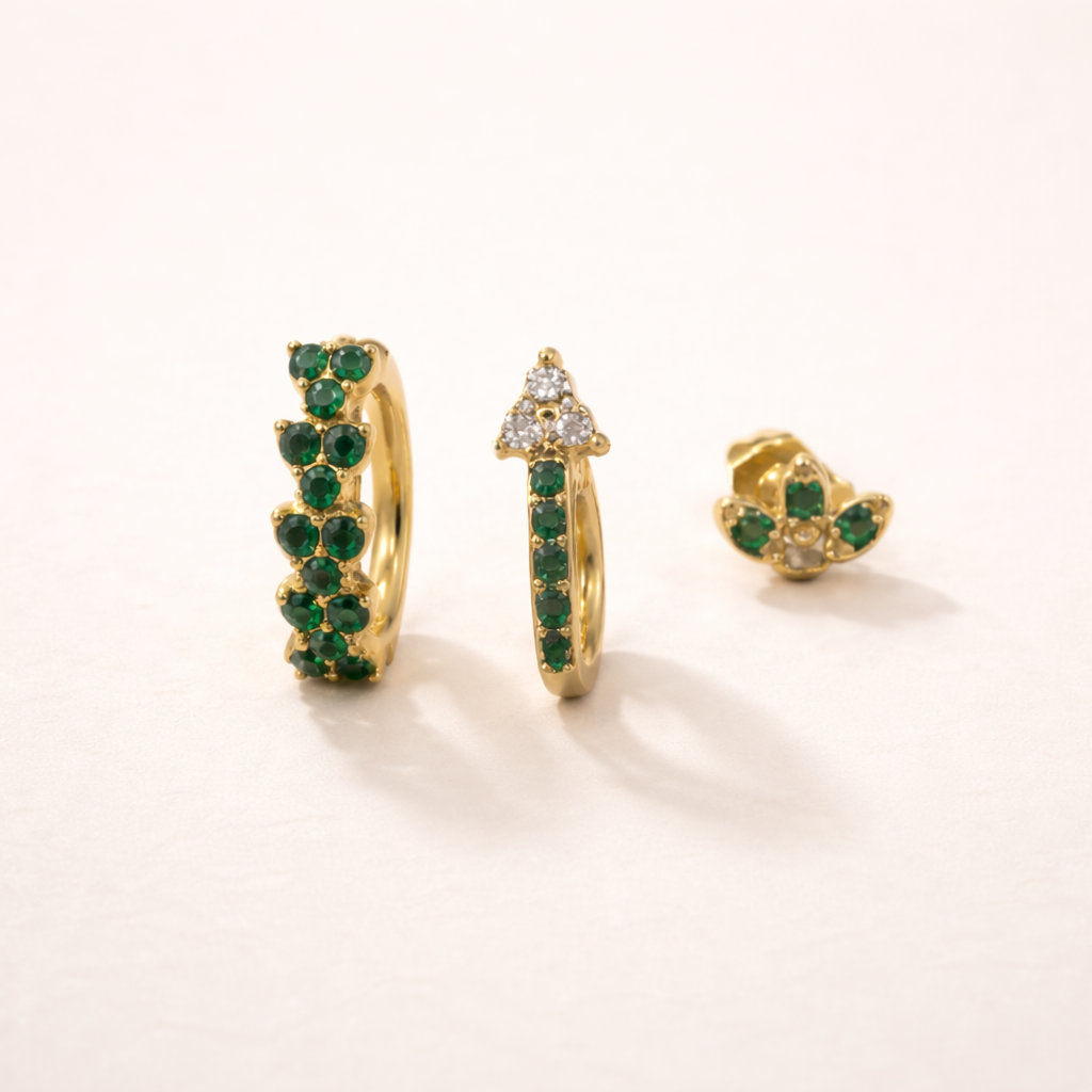 Rosalia Set of gold jewelry, a pave hoop, a hoop with a crystal-topped point, and a flower stud, all set with green stones.