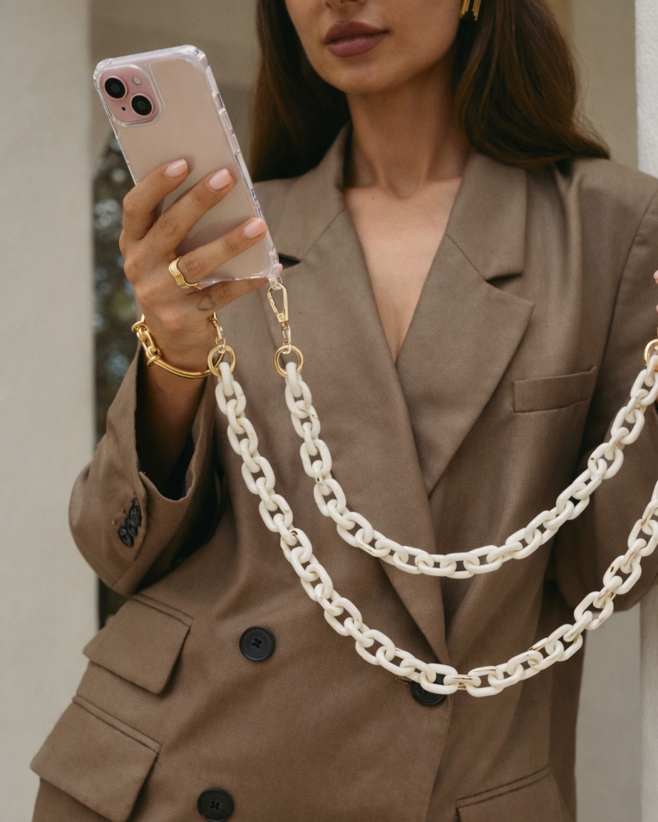 Route Long Phone Chain worn crossbody in cream, a chunky acrylic chain clipped to a clear phone case.