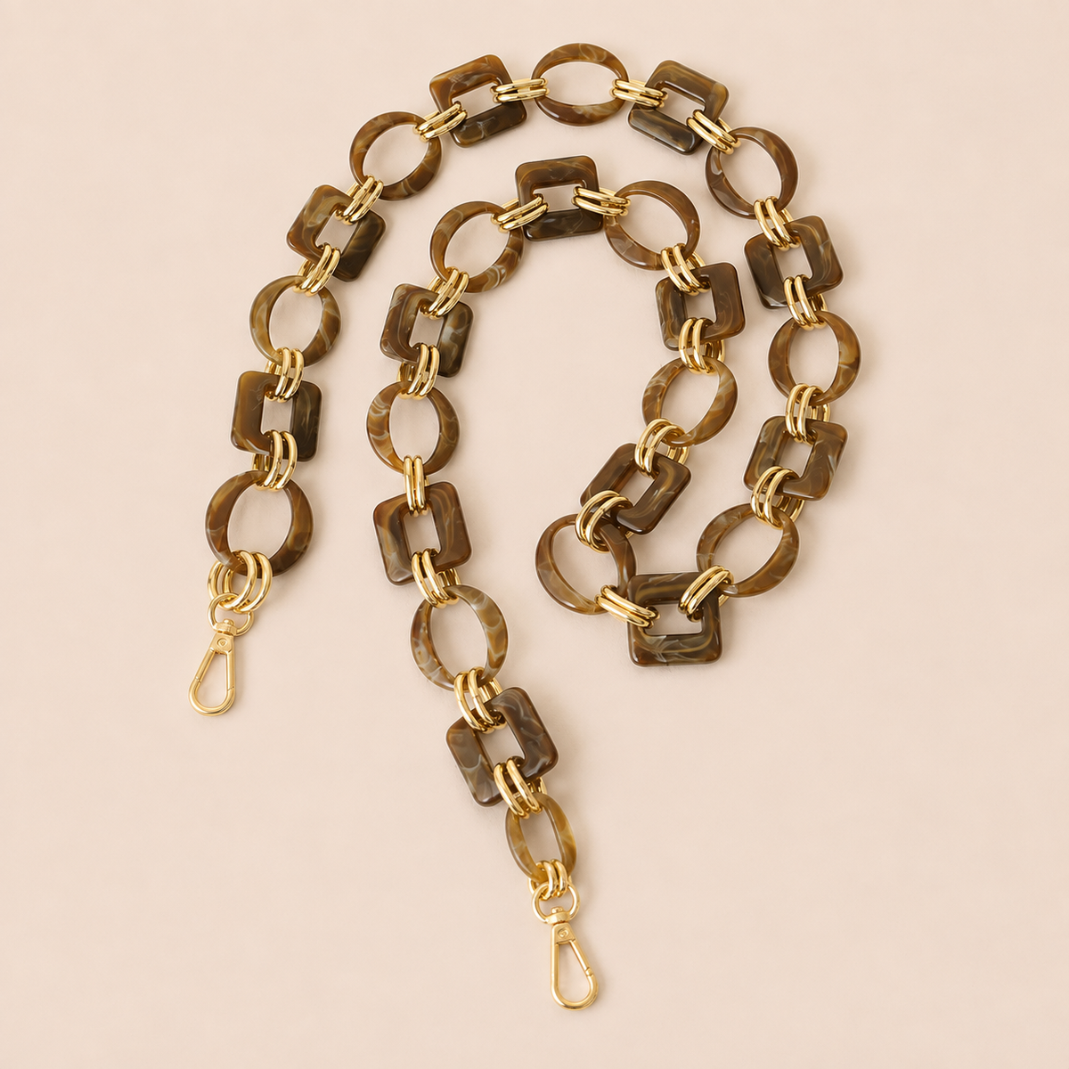 Dark brown tortoiseshell acrylic link phone chain with gold connectors coiled on cream — Folie à Trois Rowan wholesale phone chain