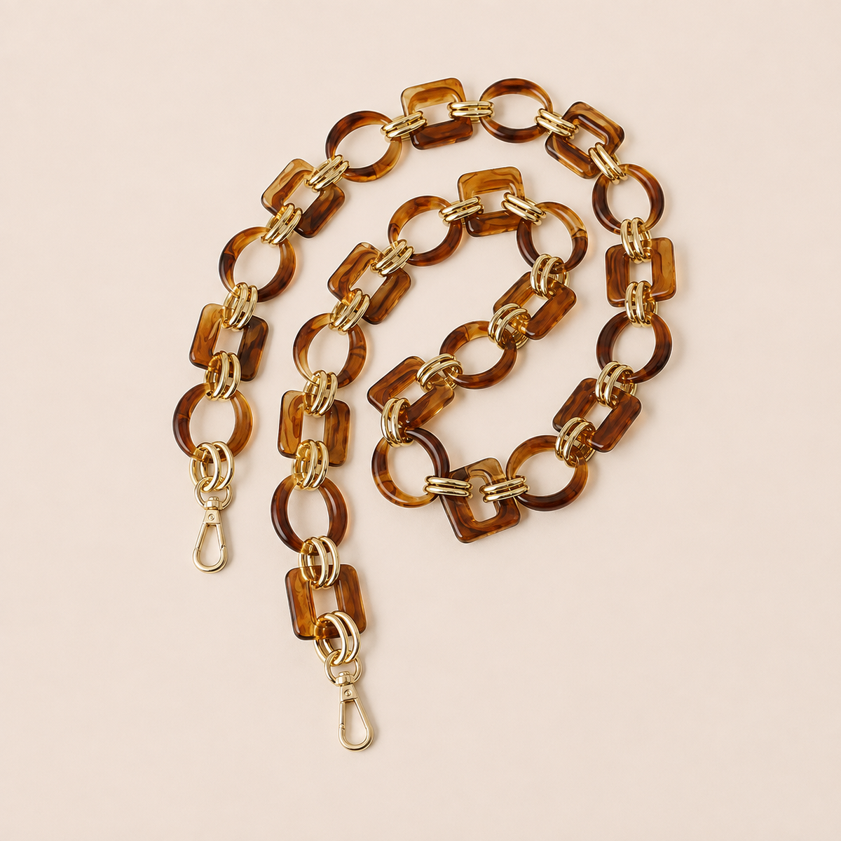 Amber tortoiseshell acrylic link phone chain with gold connectors coiled on cream — Folie à Trois Rowan wholesale phone chain