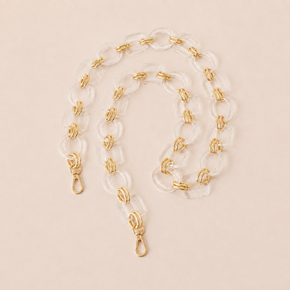 Clear acrylic link phone chain with gold connectors coiled on cream — Folie à Trois Rowan wholesale phone chain