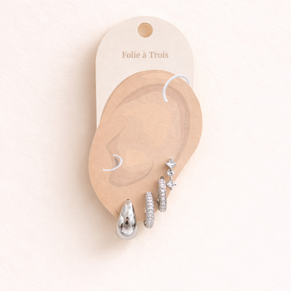Illustrated Folie a Trois earring card showing the silver-tone Roxy Set pieces on an ear-shaped display.