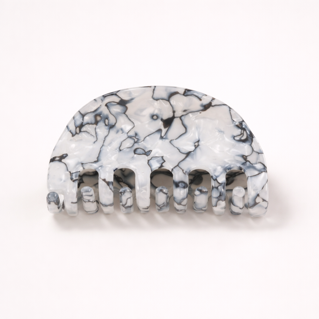 Ruth HAIR CLIP half-moon acetate claw clip in a black and white marbled pattern, studio shot.